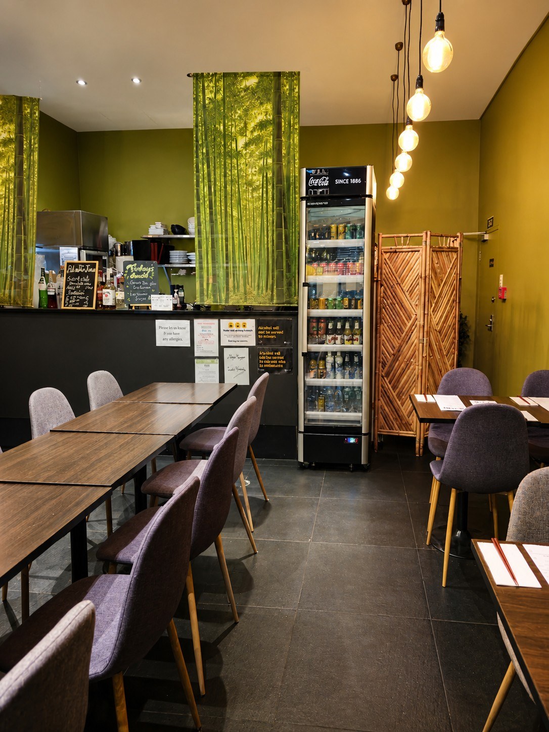 Fuga dining room in Auckland CBD with green walls, pendant lights, tables, counter and bamboo room divider