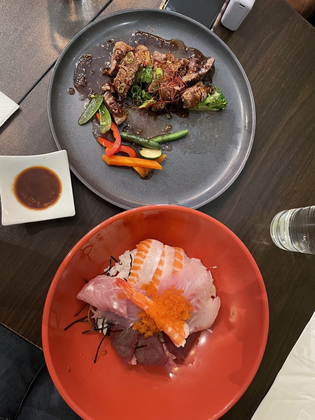 Fuga plated Japanese dishes including sliced steak, sashimi and vegetables